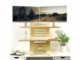 Wooden stand on table holding keyboard, hourglass, and two desktop computers