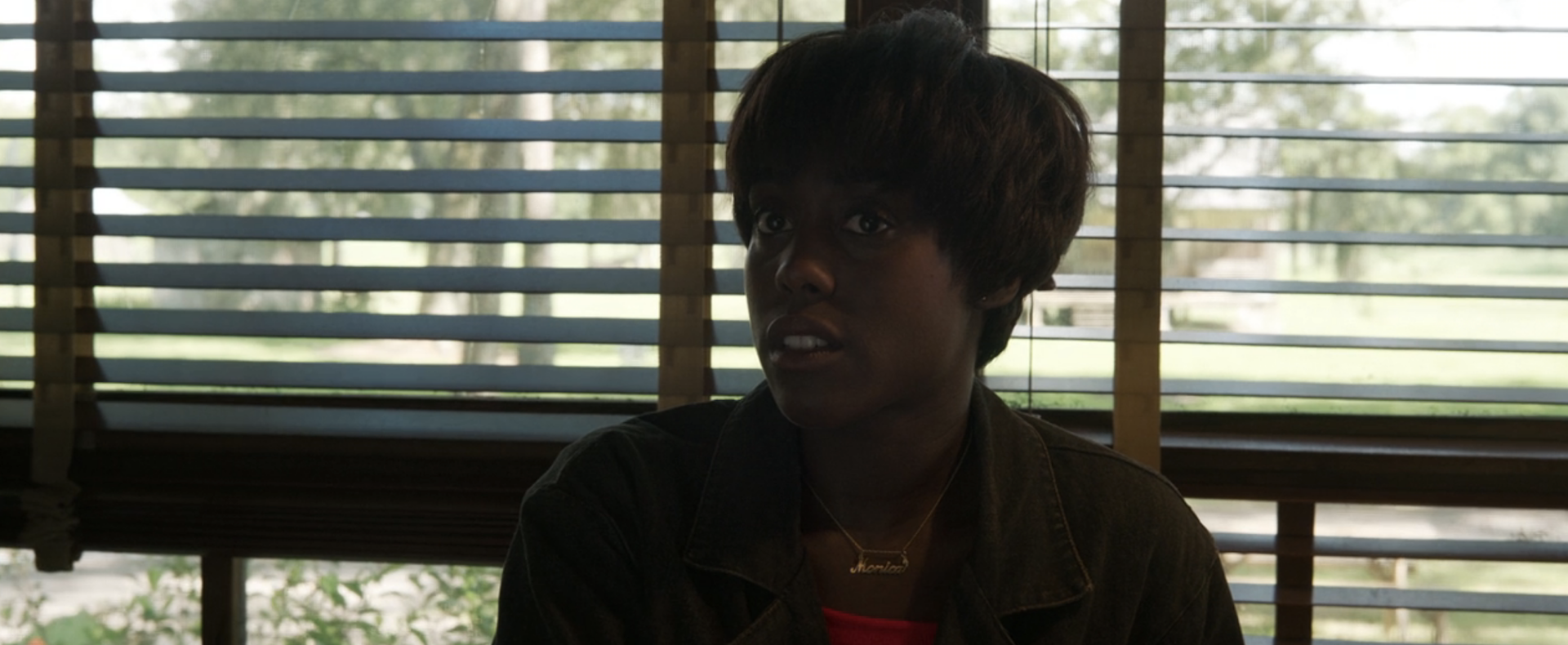 A Black woman with short dark hair looking skeptical of something.