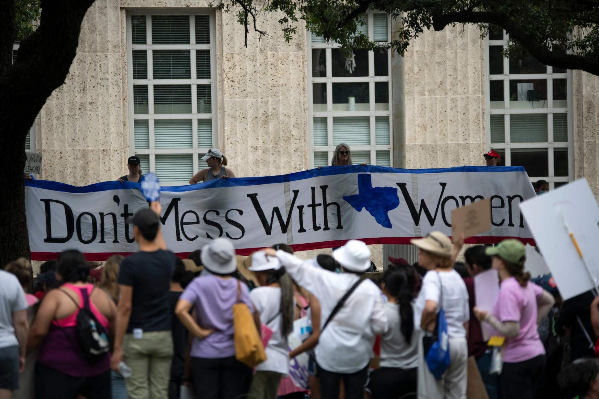 A large sign plays off of the "Don't Mess with Texas" motto, which reads "Don't mess with women".