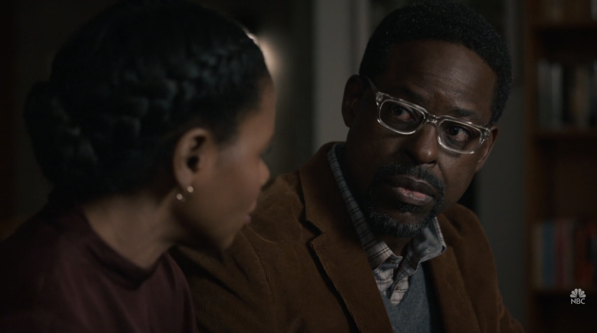 A man (Sterling K Brown) and a woman (La Trice Harper) sitting on couch talking to each other.