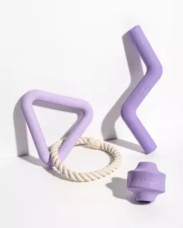 Three dynamically shaped dog toys in a light purple tone
