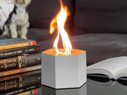 White hexagonal fire on table next to books
