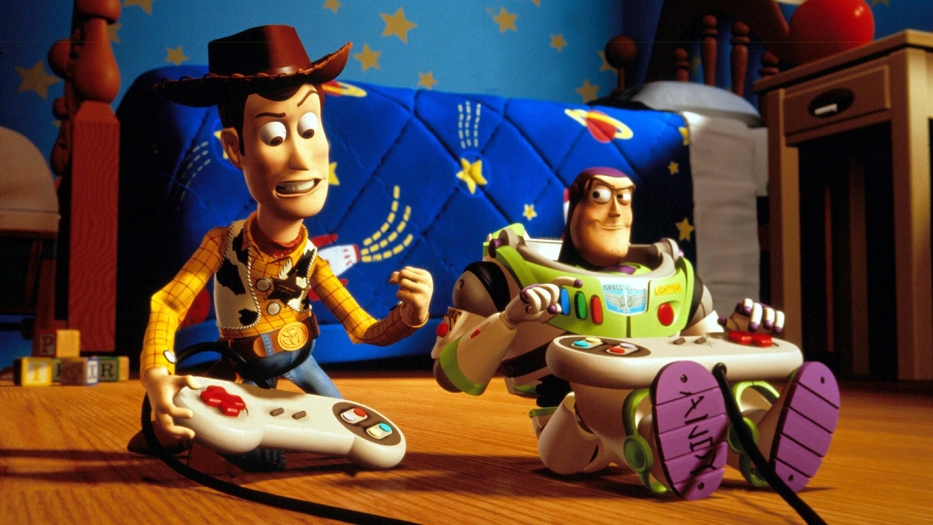 A still from "Toy Story 2." Woody and Buzz Lightyear sit side by side in a child's bedroom. They're both holding video game controllers.