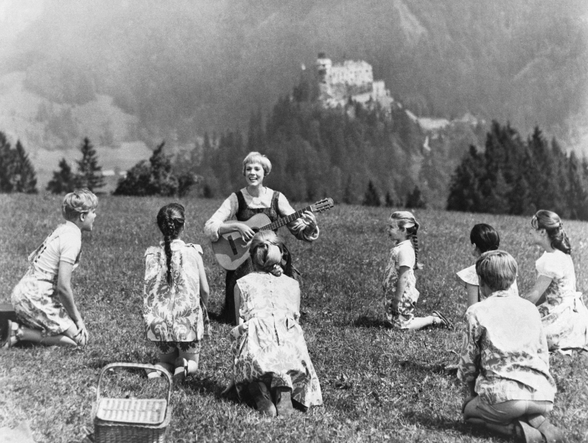 Julie Andrews and the cast of "The Sound of Music" singing outdoors.