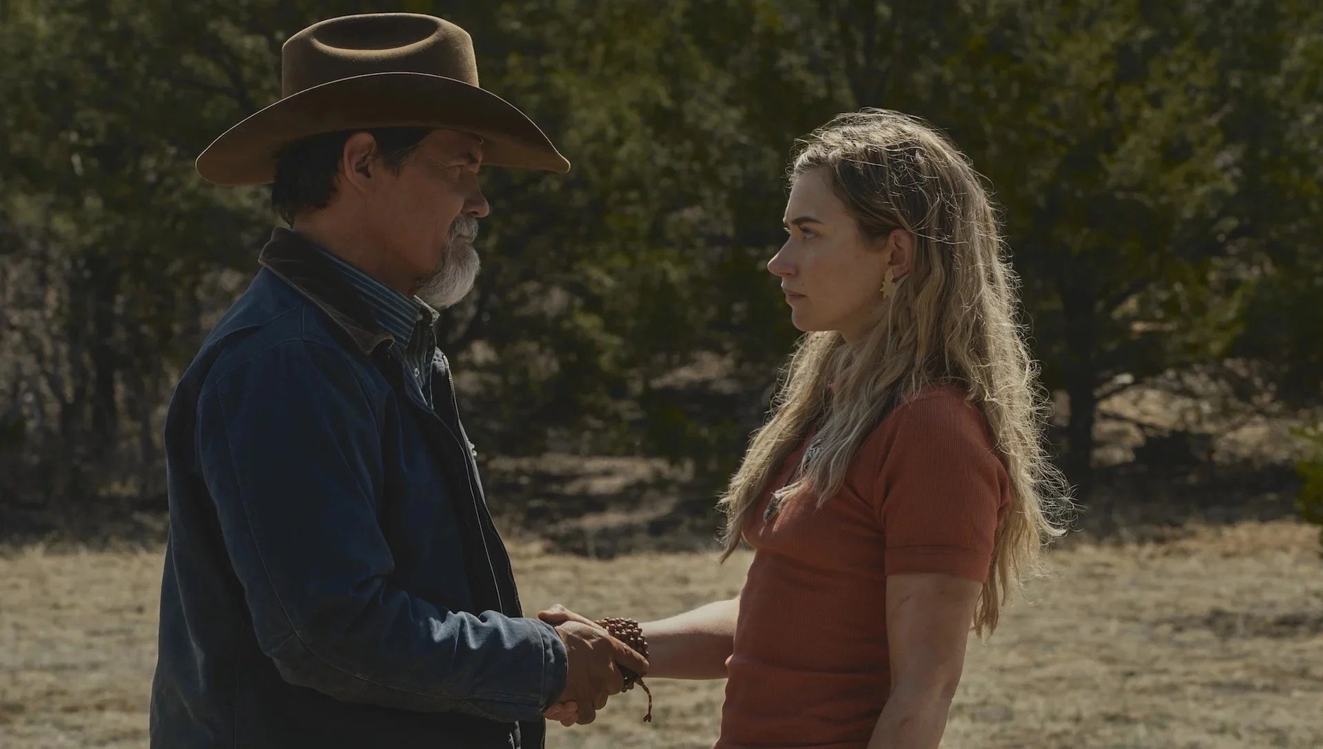 A man in a cowboy hat and a woman shaking hands.