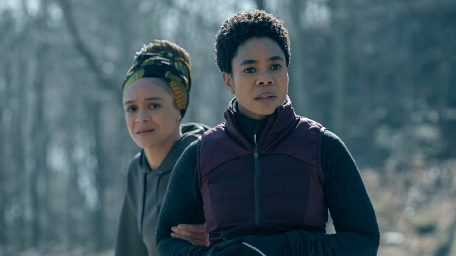 Two Black women look afraid on a jogging path.
