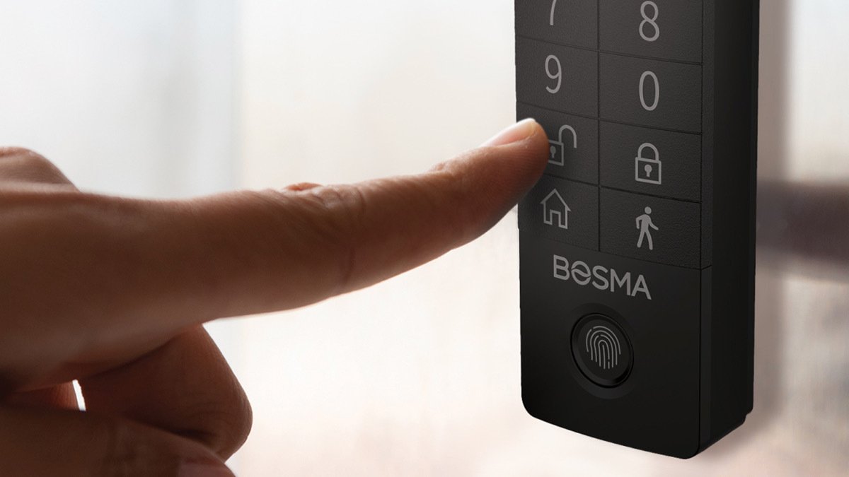Finger pressing unlock button on black Bosma keypad lock