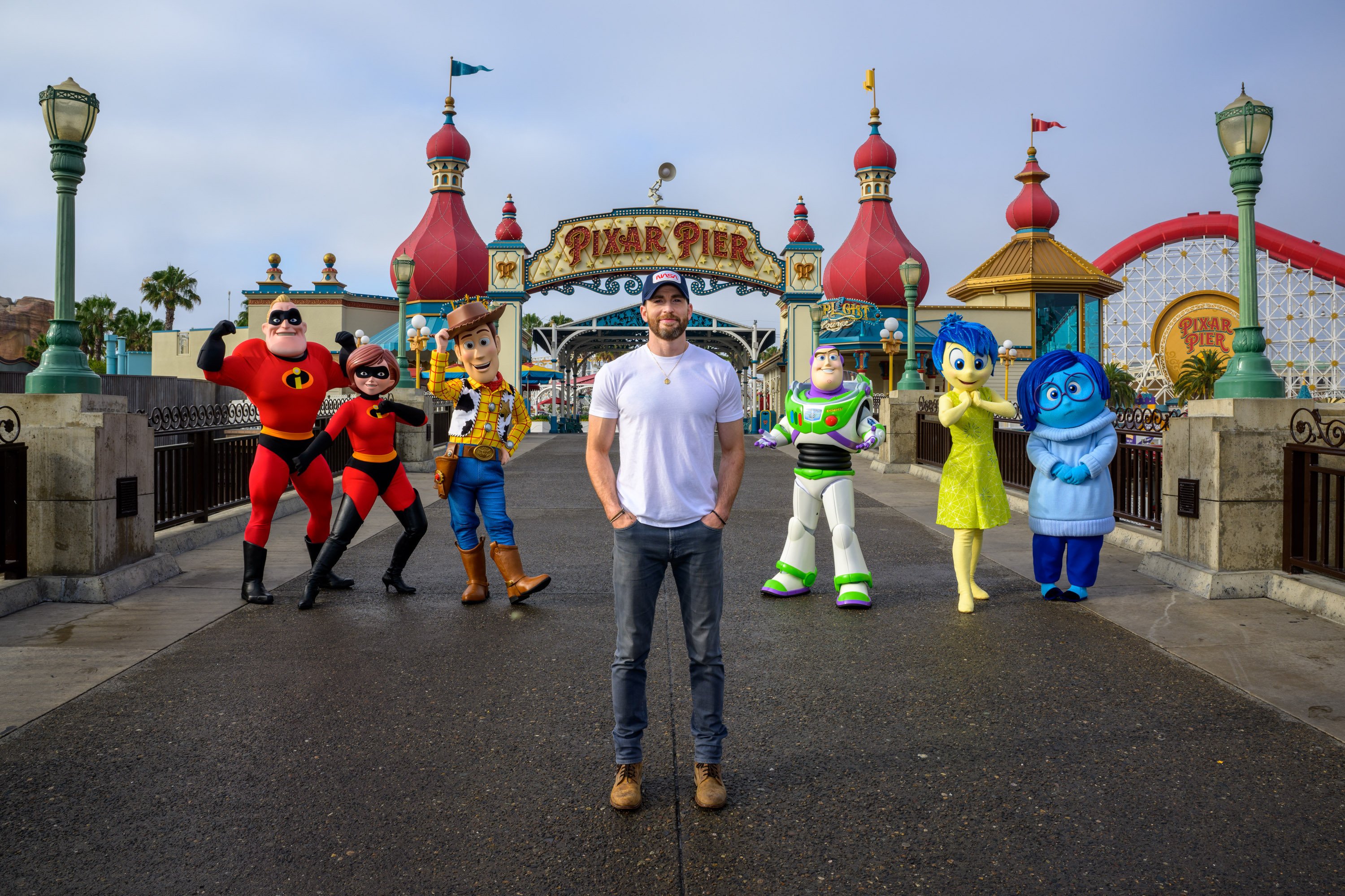 Chris Evans poses with Pixar characters at Disneyland California.