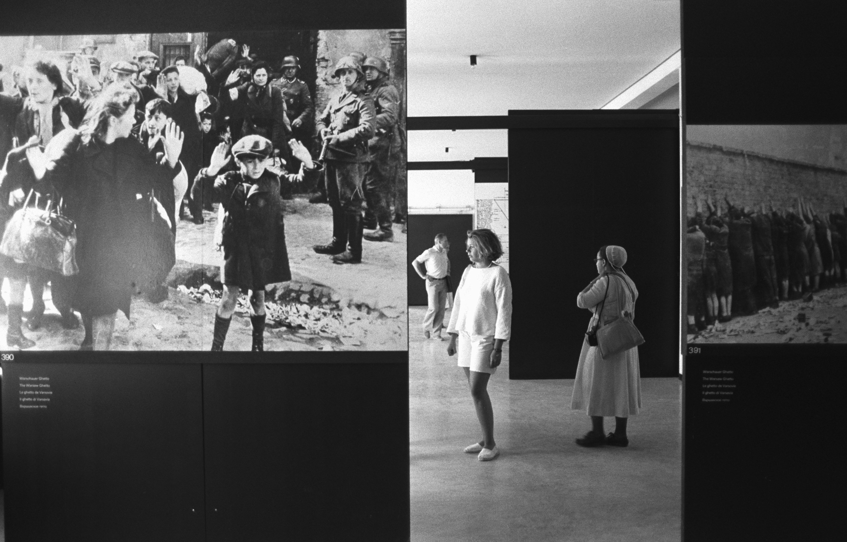Visitors Looking at Holocaust Photographs in Concentration Camp - stock photo