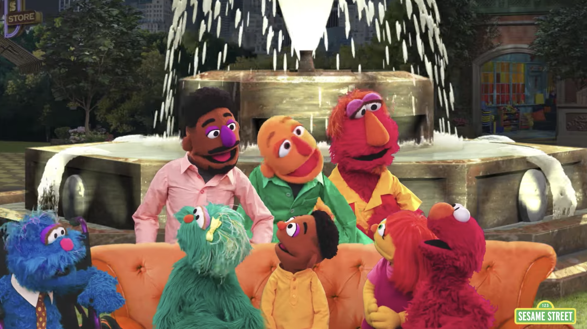 Sesame Street puppets sit on the iconic 'Friends' couch, in front of the fountain.