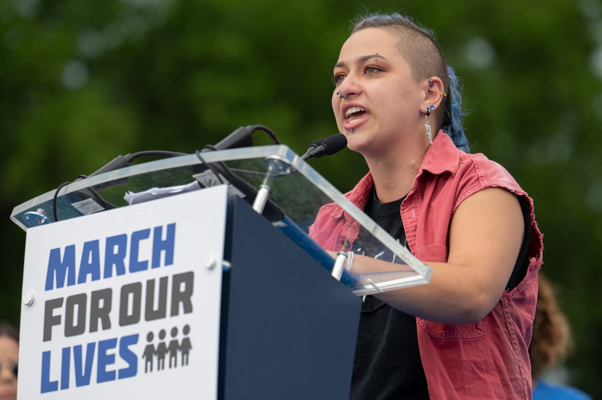 march for our lives co-founder x gonzalez speaks at podium with march for our lives logo on it