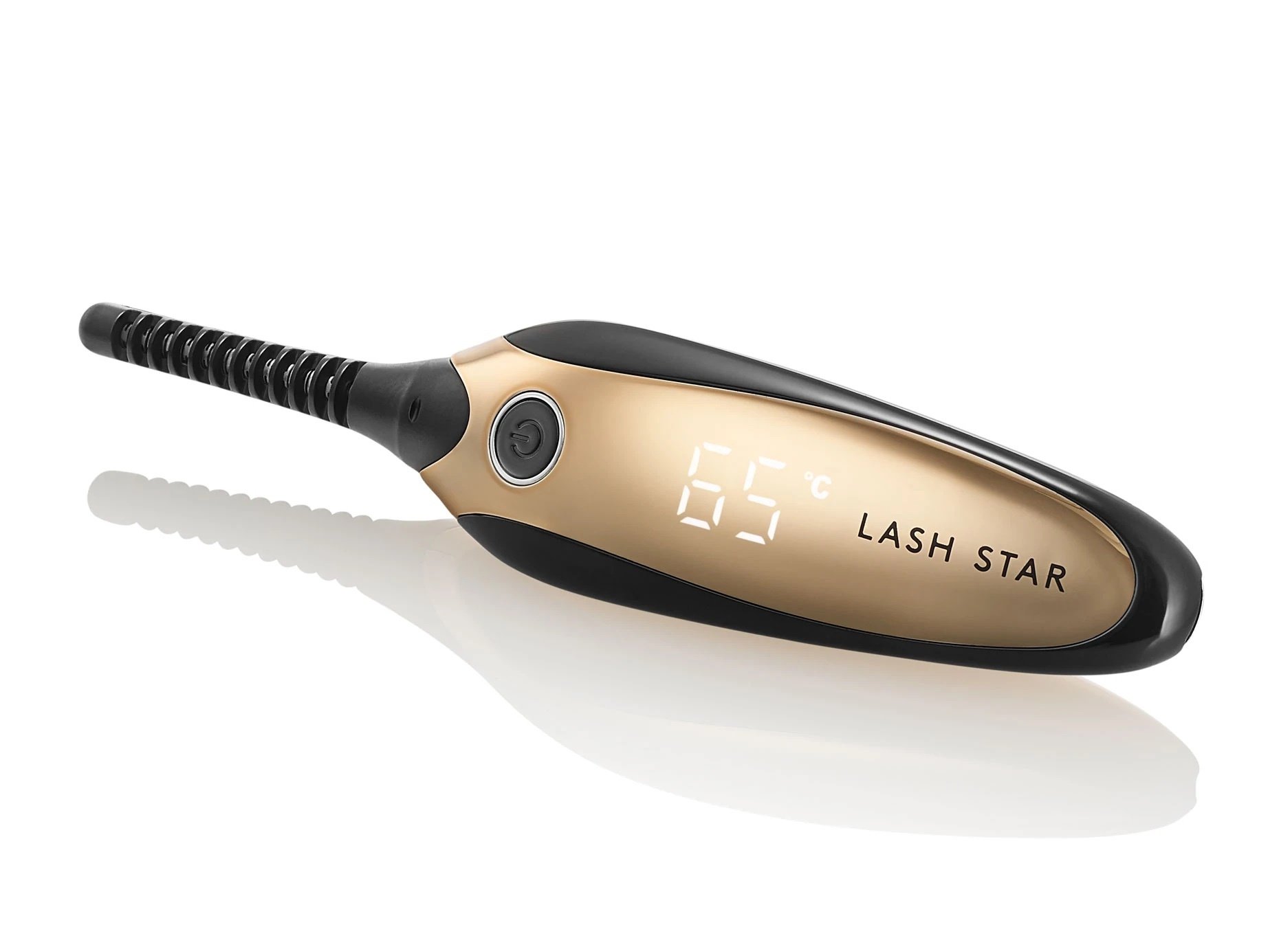 Black and gold oval device with a black skinny rod for curling lashes. The gold surface reads 65 degrees Fahrenheit. 