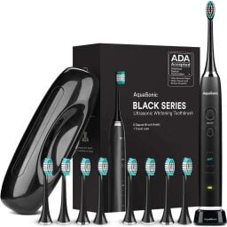 AquaSonic Black Series ultra whitening electric toothbrush in front of box and with eight brush heads and travel case.