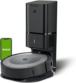 Black robot vacuum at charging station with phone showing irobot app screen