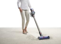 person vacuuming carpet with dyson v8 animal 
