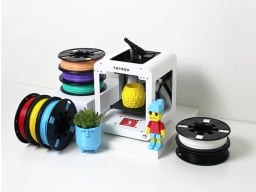 White 3d printer surrounded by spools of printing material
