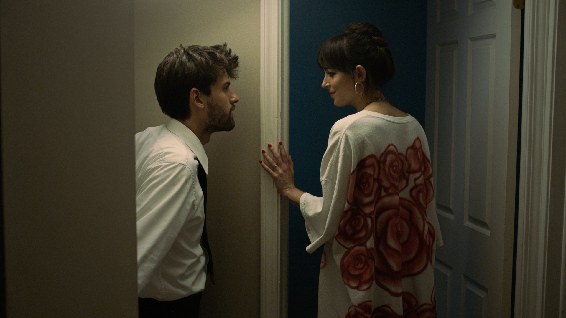 Two people in a hallway looking at each other.