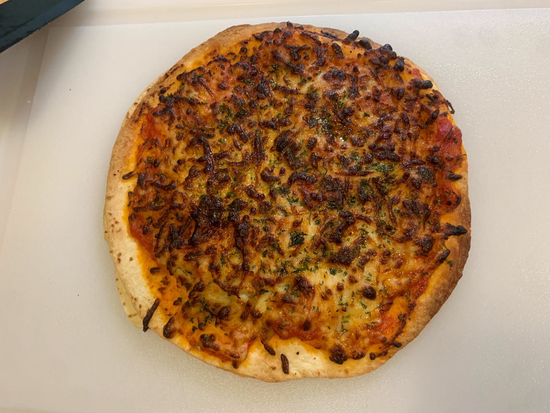 tortilla pizza on cutting board