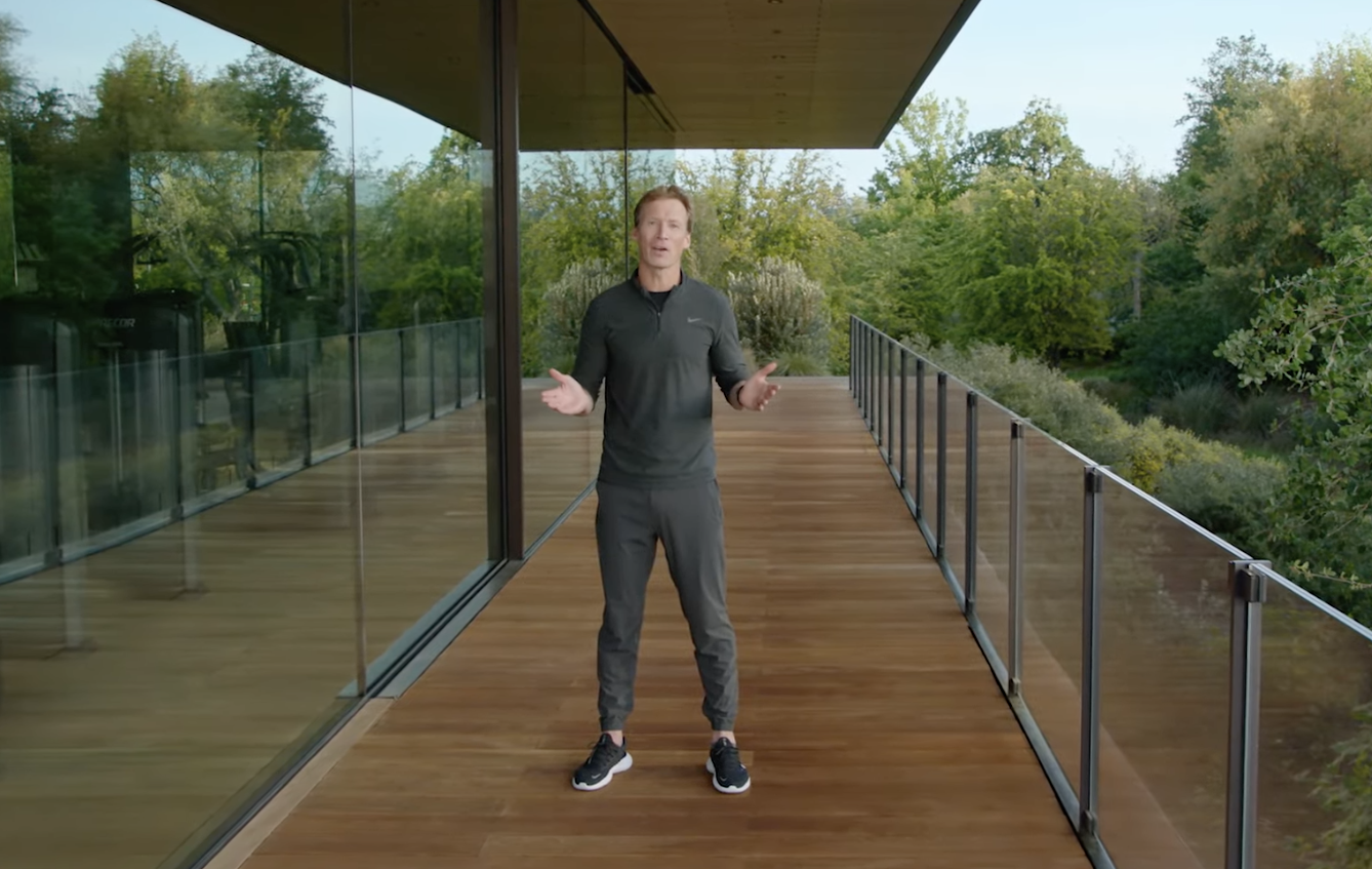 Craig Bolton stands on a balcony in a space grey Nike tracksuit and shoes.