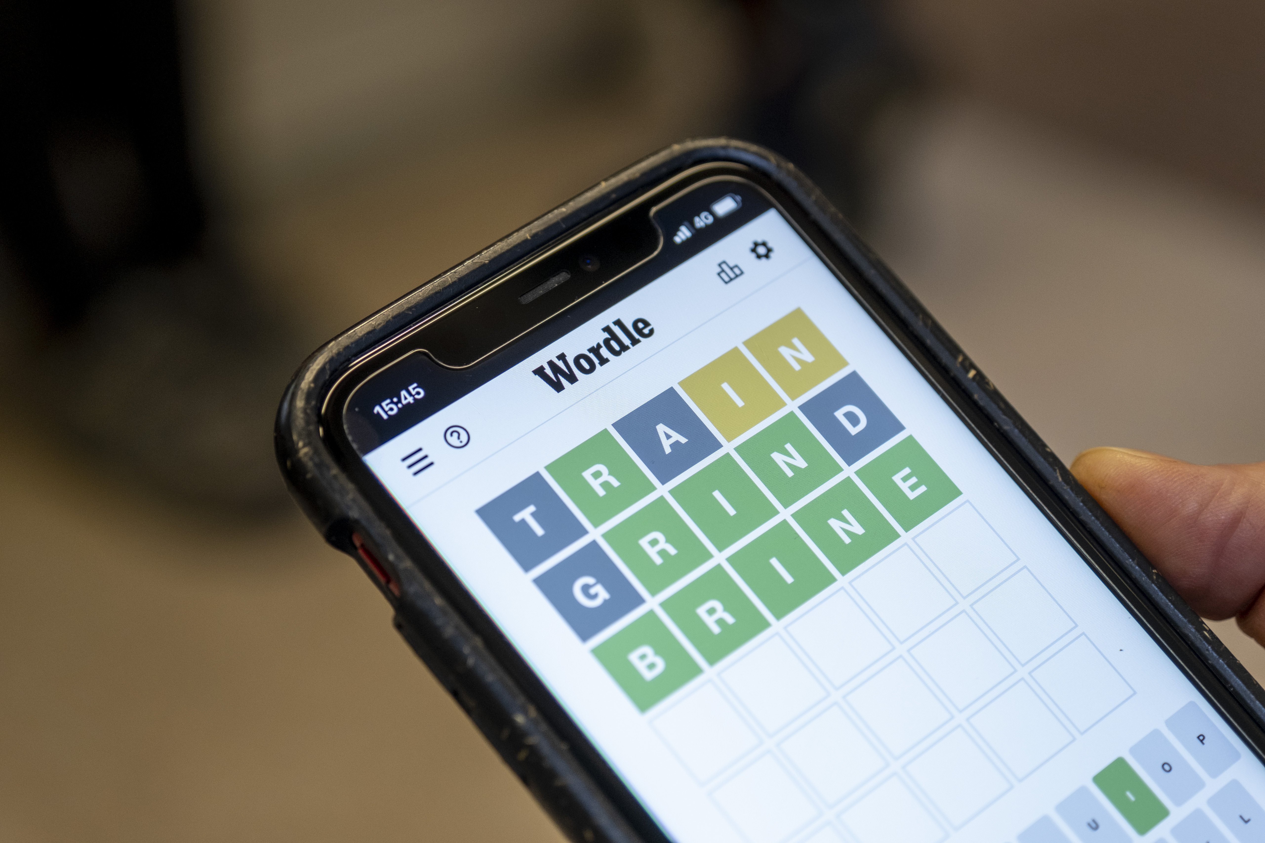 A smartphone with the Wordle game displayed.