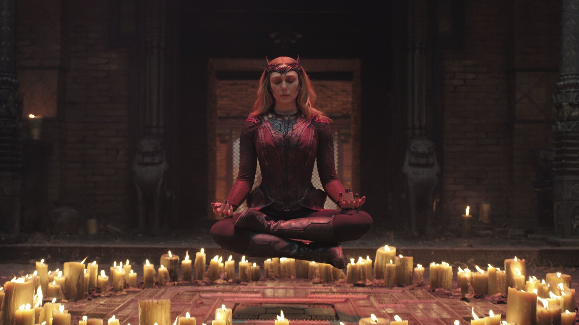 A superhero meditates while floating over candles.