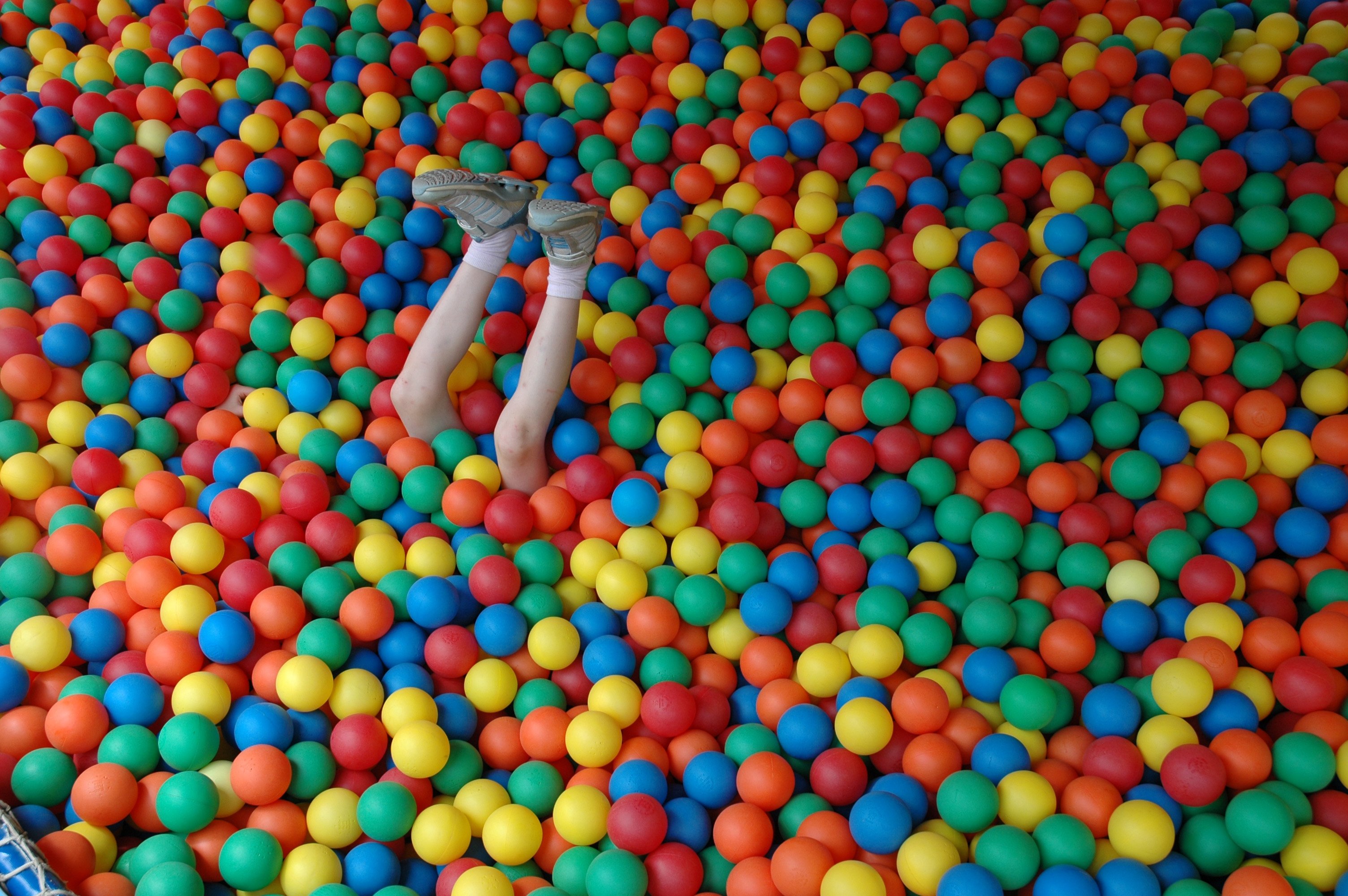 View of human legs amid colorful balls
