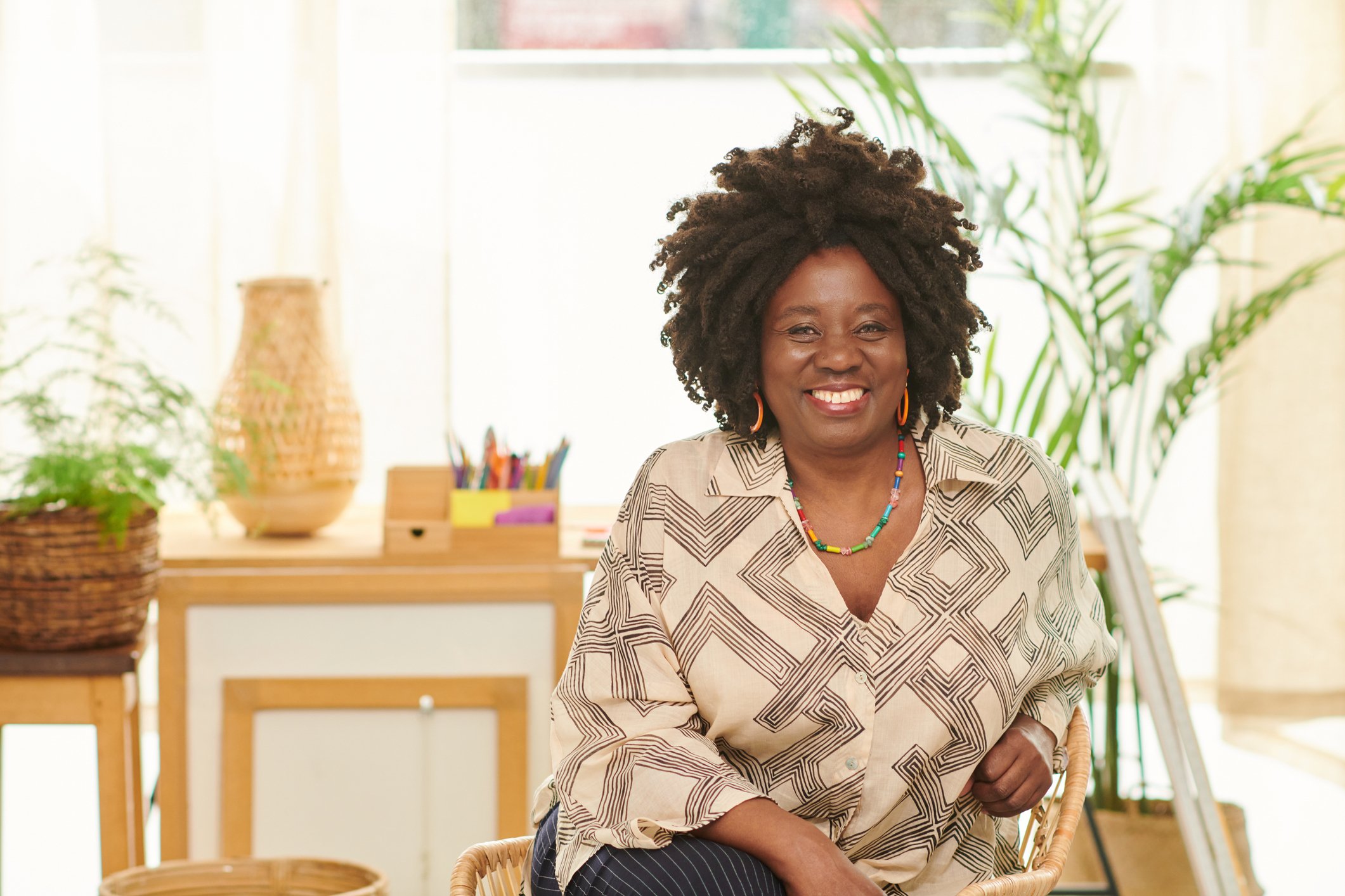 Woman sits confidently and happy in her bright and airy living room