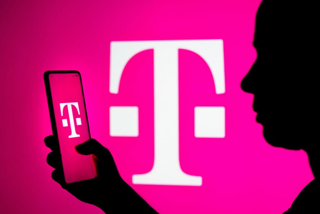 Woman holding phone with T-Mobile logo on it