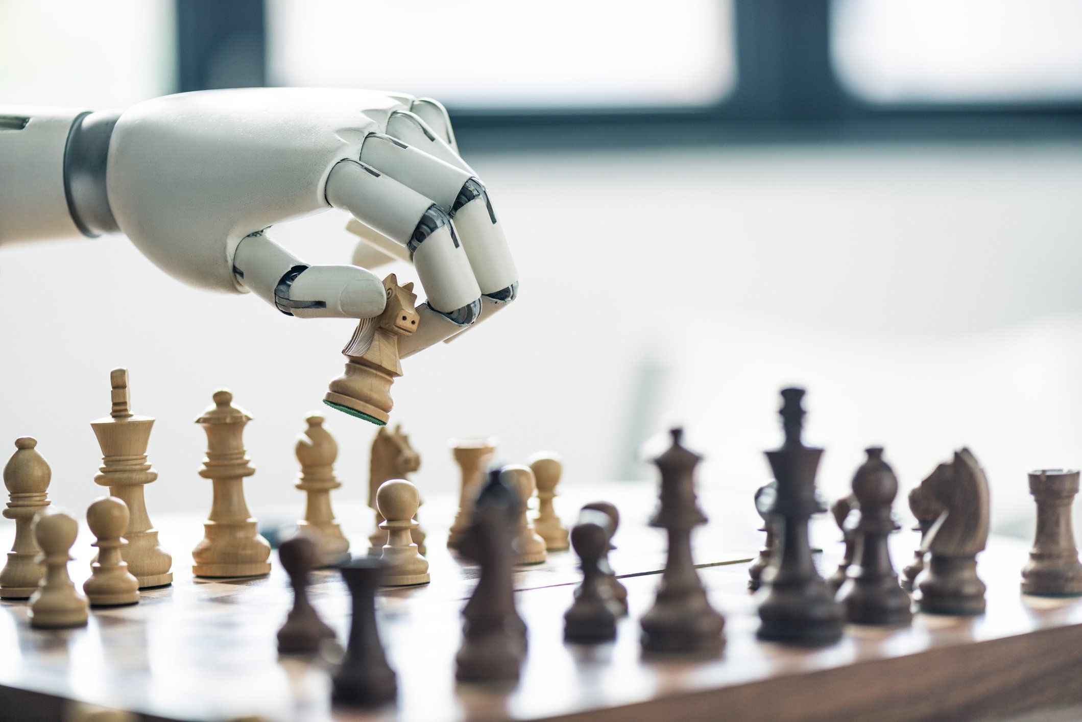 Image of robot hand moving a chess piece on a board