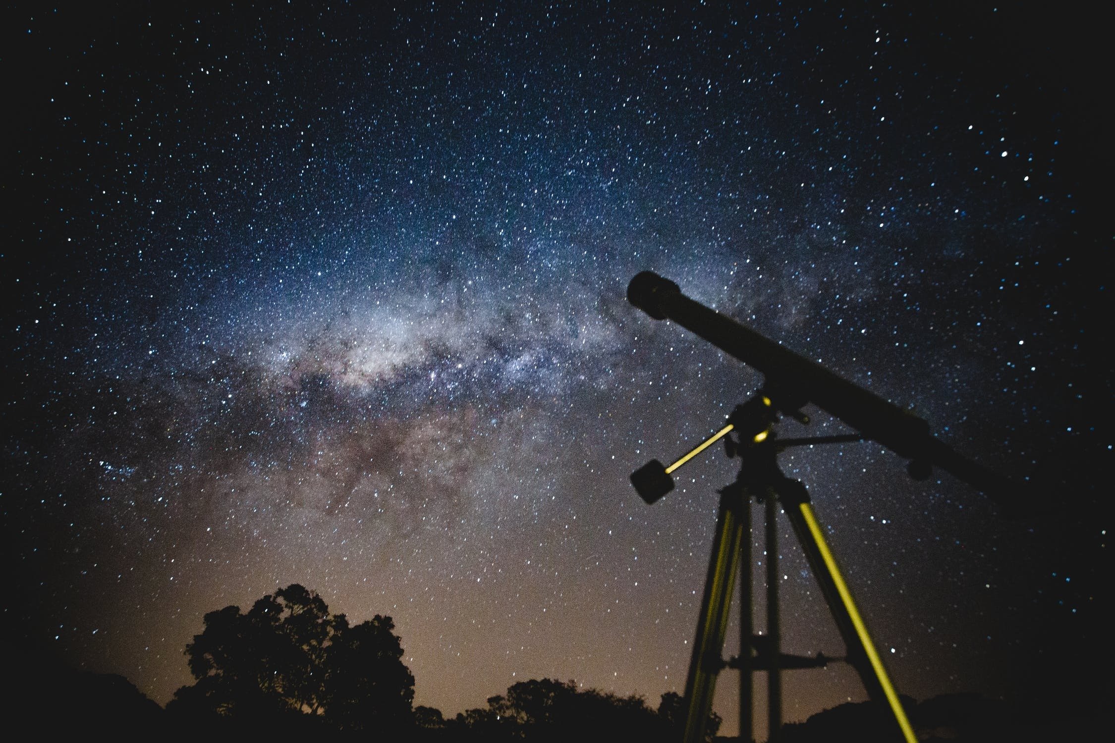 Telescope under a black and blue sky