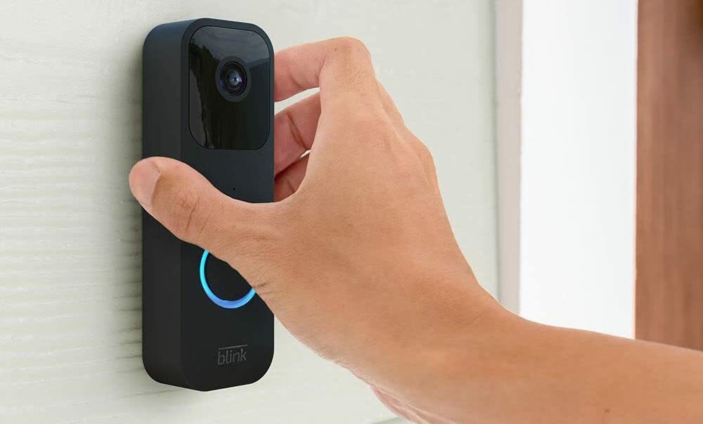 Hand touching a smart doorbell
