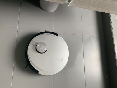 Ecovacs robot vacuum on gray tiled floor