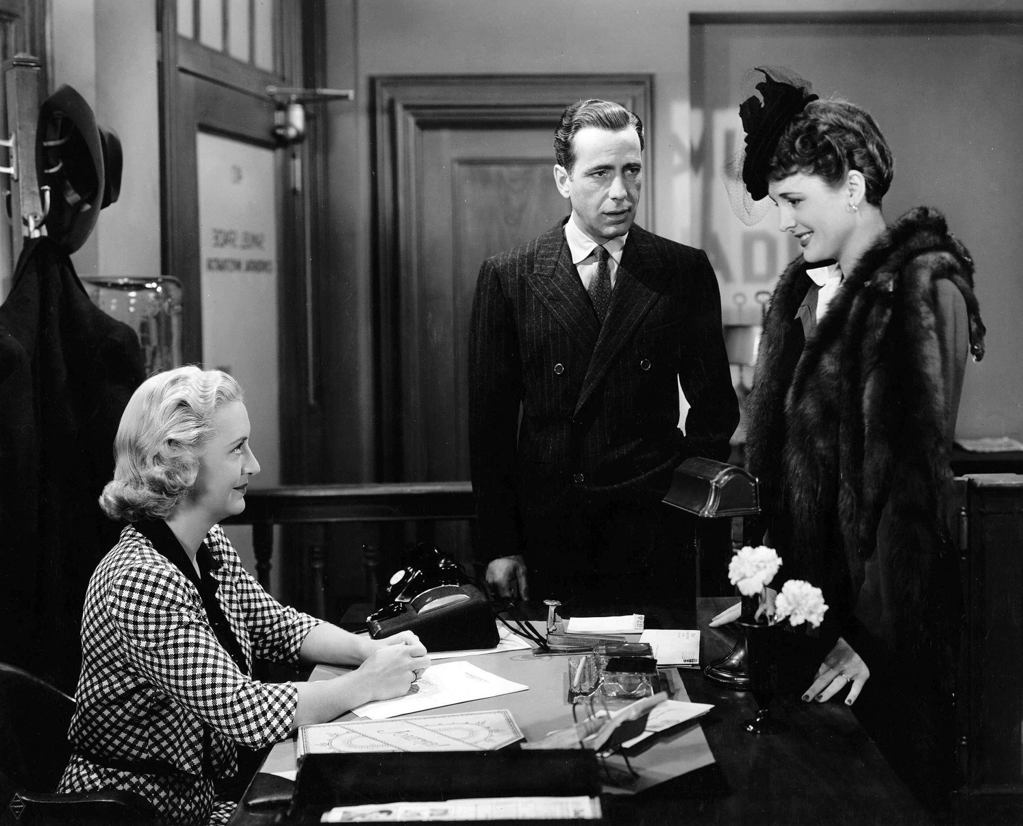Humphrey Bogart, Mary Astor, and Lee Patrick talk in an office in "the Maltese Falcon."