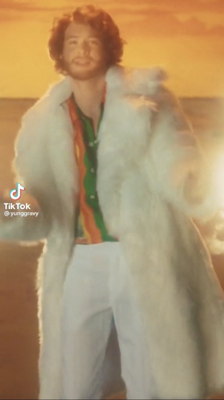 Yung Gravy dancing in a white coat.