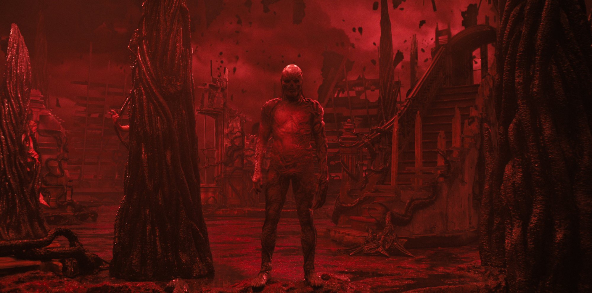 A humanoid figure covered in tentacles stands menacingly in a red, hellish landscape.
