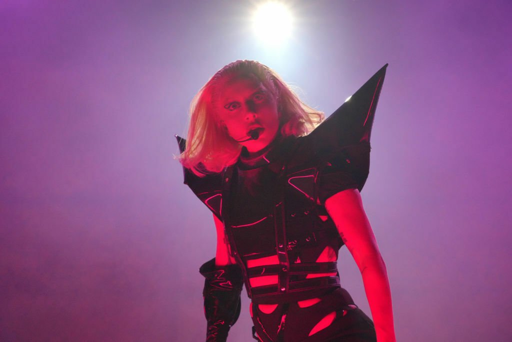 Lady Gaga performing in a black bodysuit with pointy shoulder pieces.