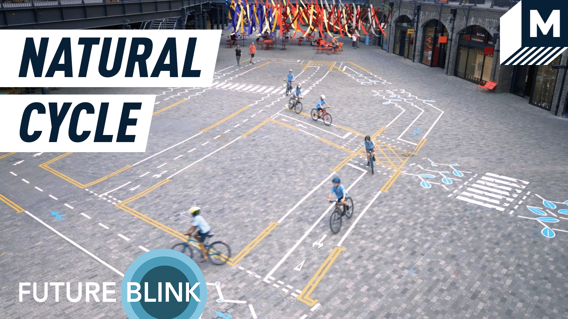 A top down view of children riding bicycles over the painted art installation 