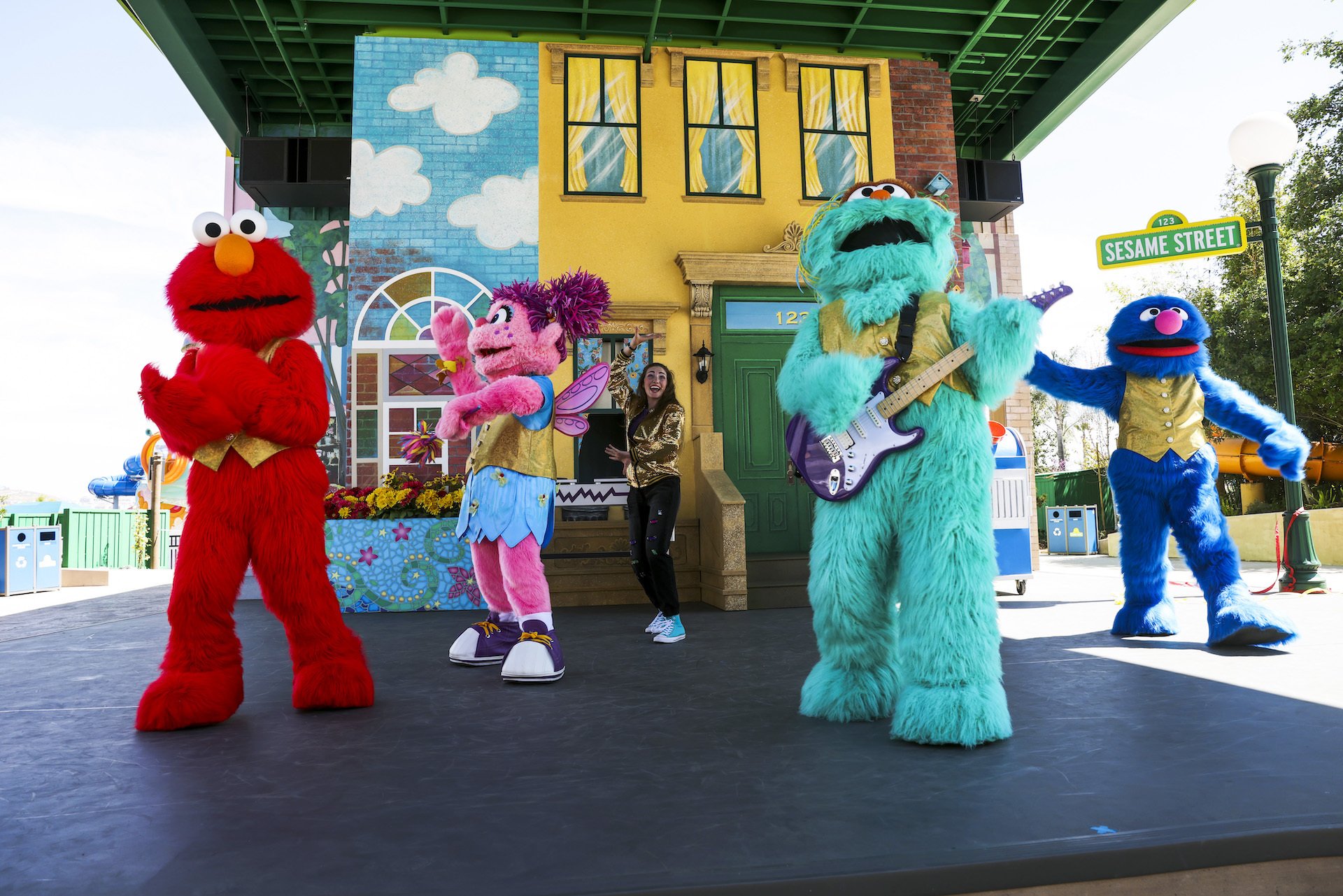 Popular Sesame Street characters dance on stage at a Sesame Place theme Park.