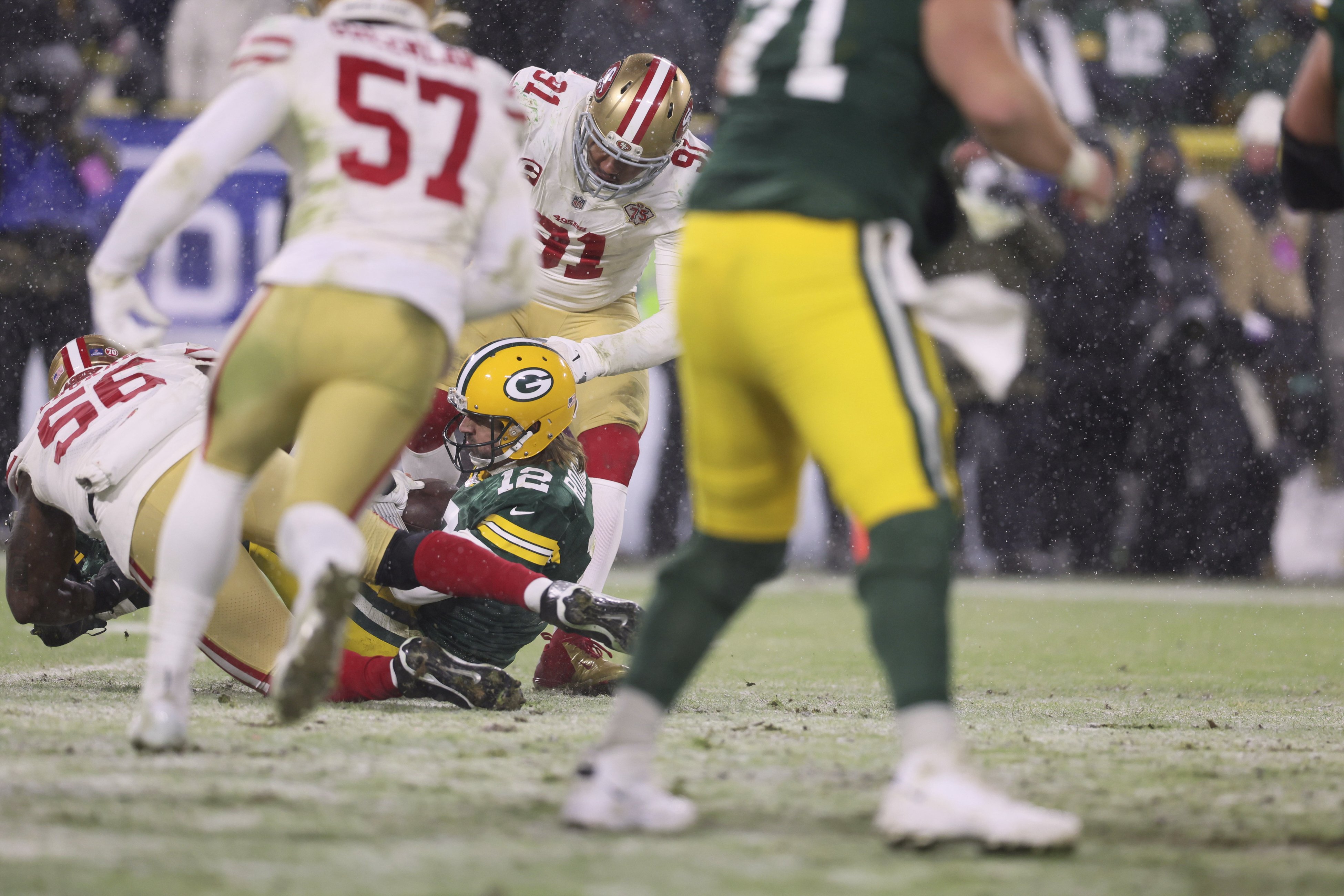 Members of the Green Bay Packers scramble to prevent members of the San Francisco 49ers from getting the football