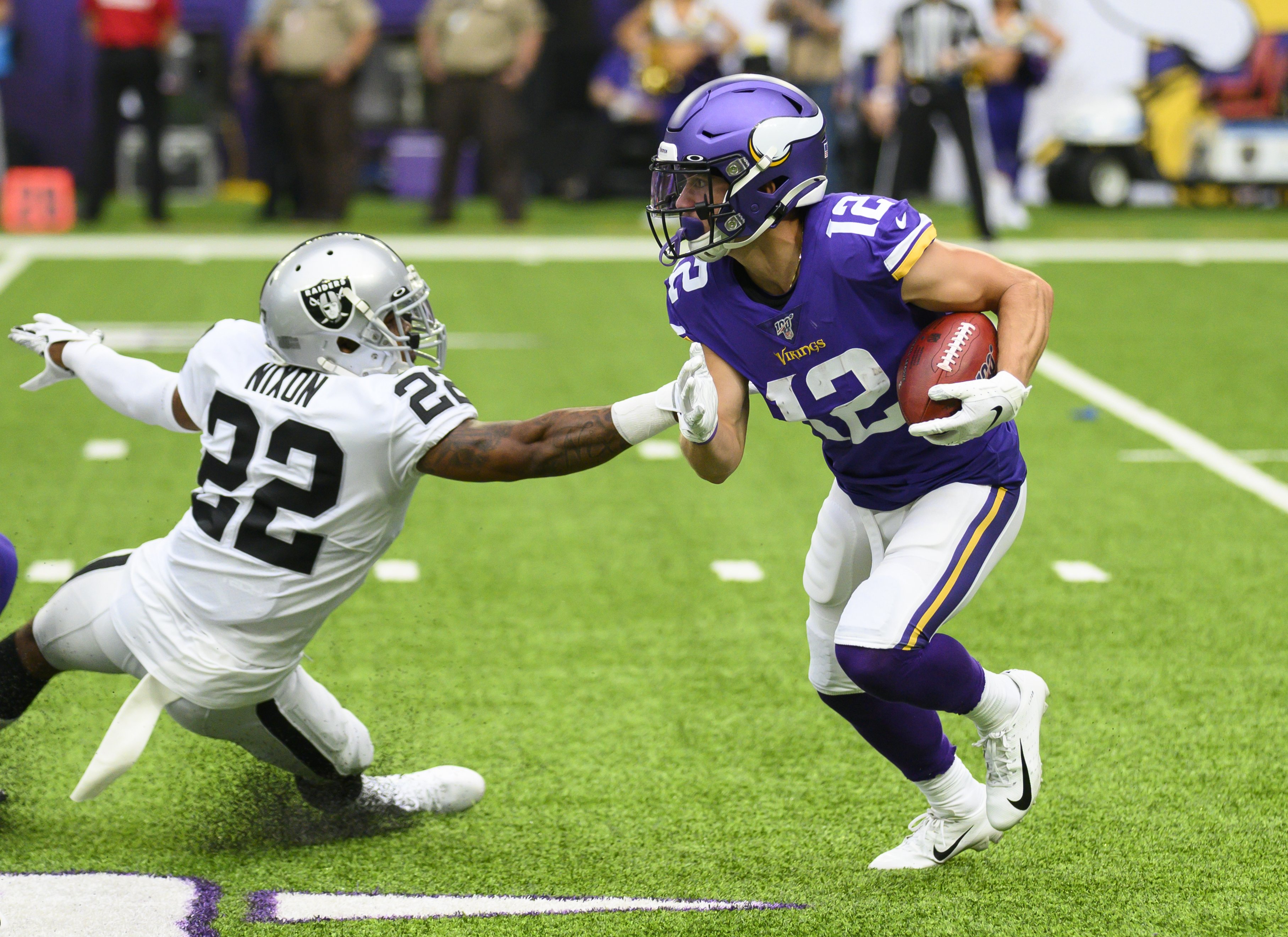 A Raider attempts to block a running Viking in an NFL game