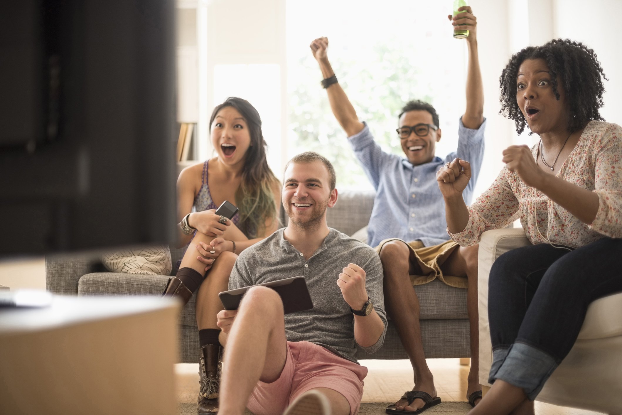 group of friends watching TV and cheering