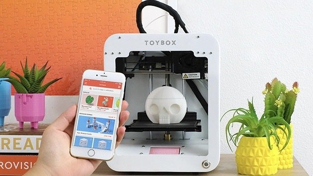 Toybox 3D Printer Deluxe Bundle on a table.