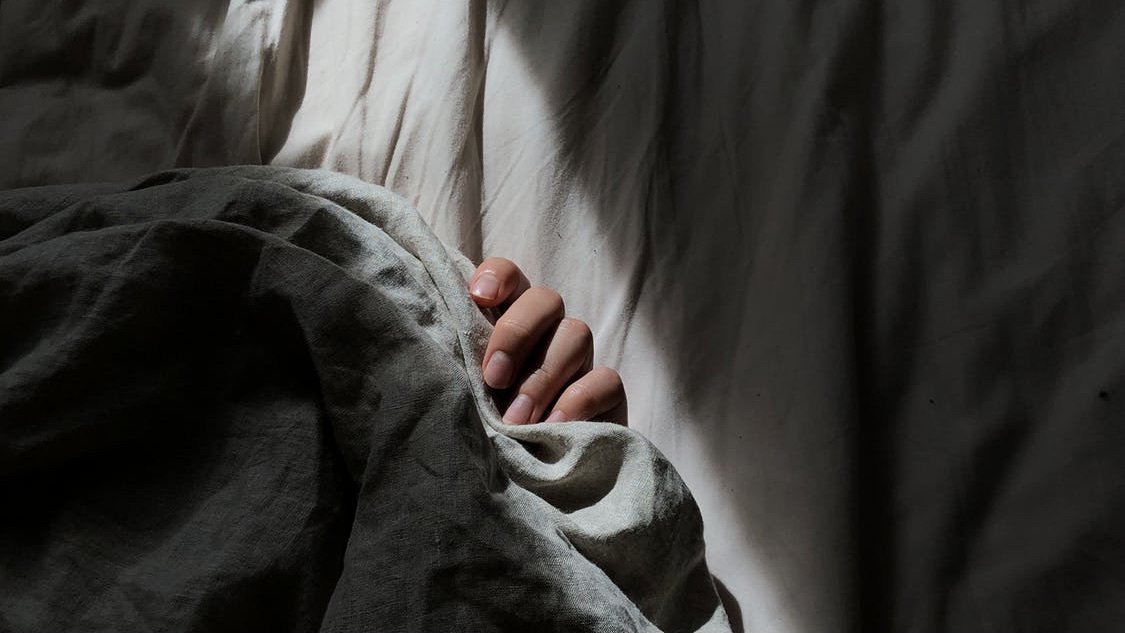 a person gripping on to bedsheets