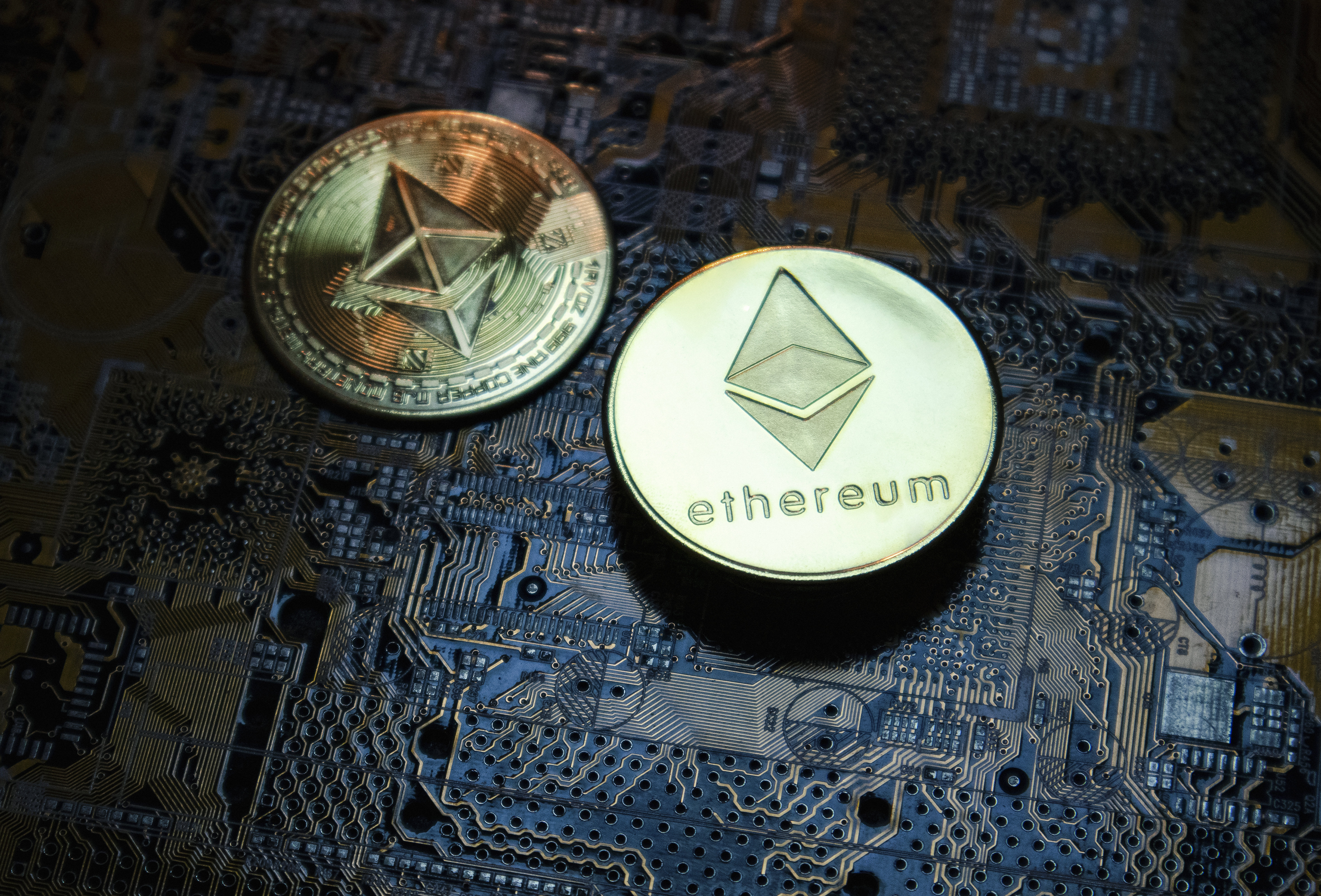 two physical coins marked with the Ethereum logo