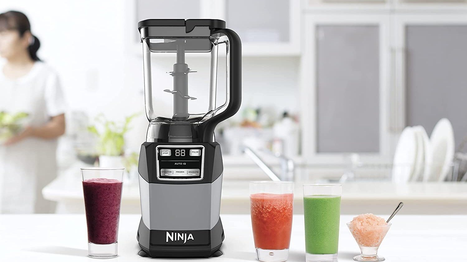 ninja compact kitchen system on a kitchen counter with glasses on blended drinks
