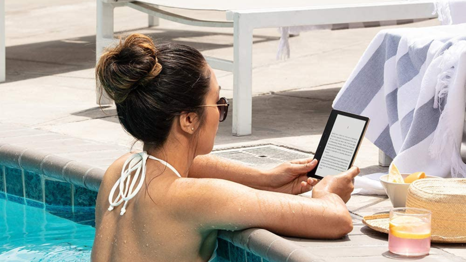 woman reading on kindle oasis while in the pool