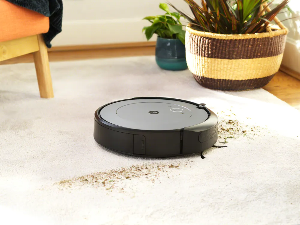 Roomba i2 robot vacuum cleaning debris on carpet