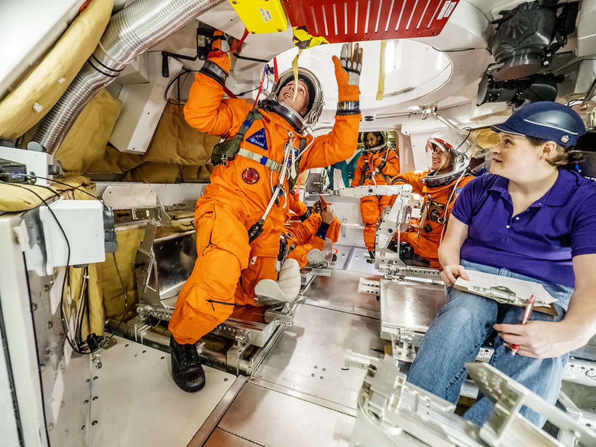 Astronauts examining Orion spacecraft