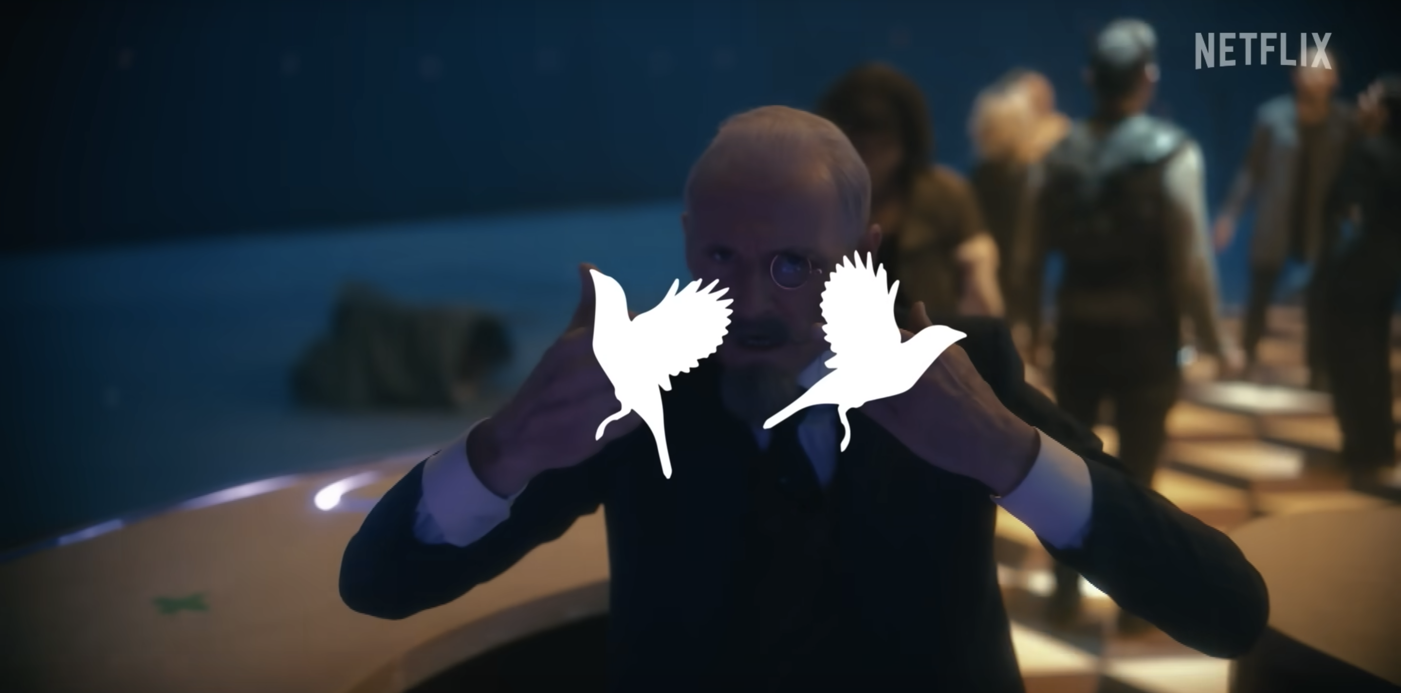 Sir Reginald Hargreeves (Colm Feore) from 'Umbrella Academy' sticking up both his middle fingers. His hands are censored by silhouettes of sparrows.