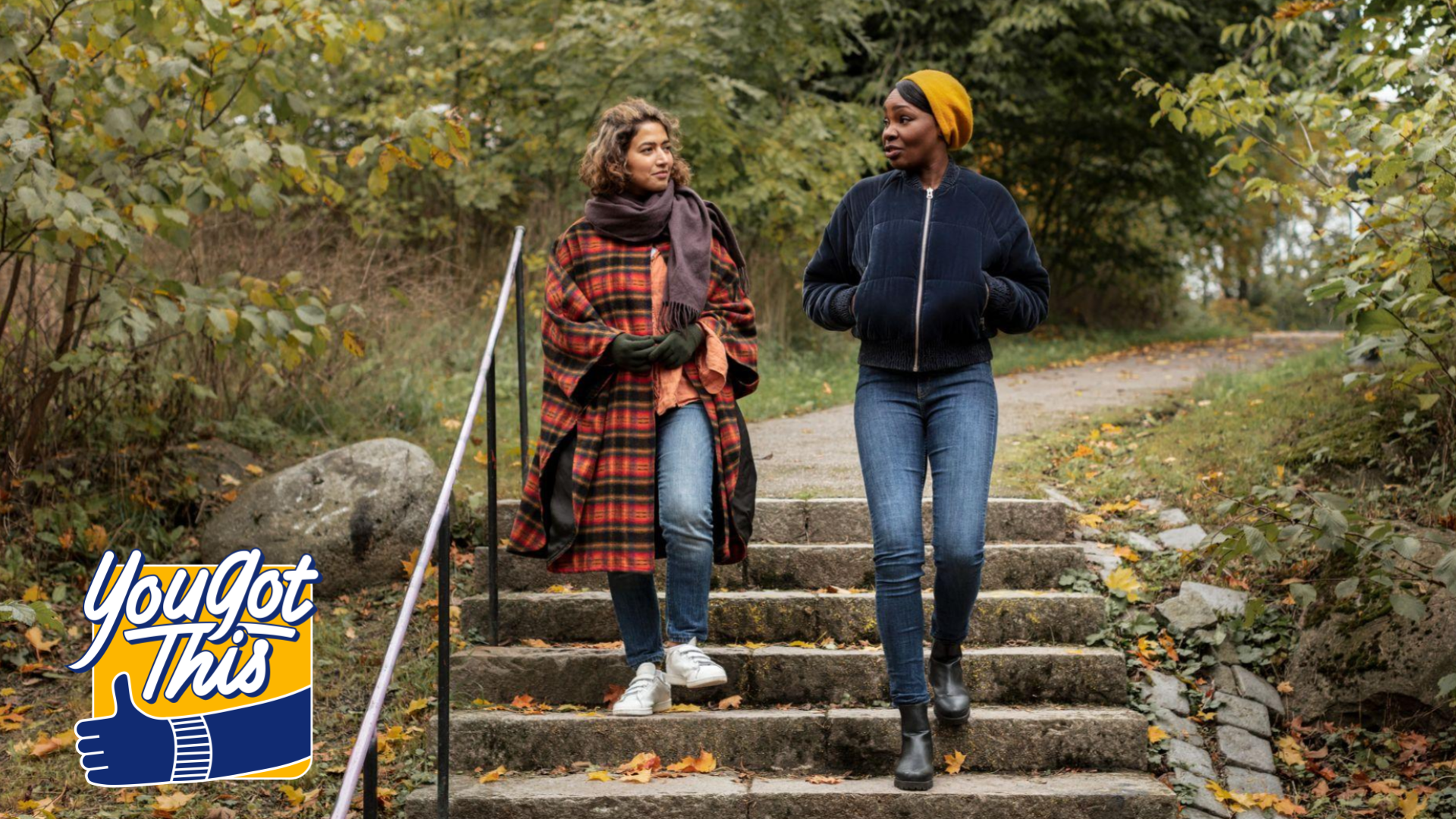 Two people wearing fall clothes walking down stairs in park